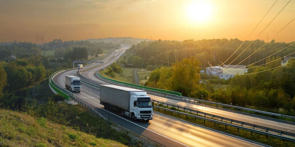 Semi trucks on a winding road at sunrise