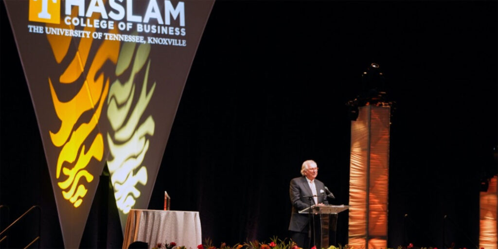 Man at podium at gala event.